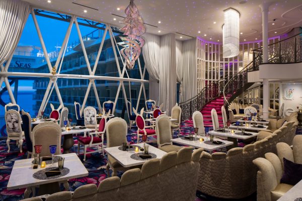 Wonderland SY, Symphony of the Seas, Wonderland - Deck 12 Aft Center, restaurant interior, table seating, stairway, night, evening, dusk, night, window view, colorful, fantasy decor,